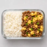 Top-down view of Ground Beef Eggs and Rice Meal Prep in a square meal container, ideal for simple, protein-packed weekday meals.